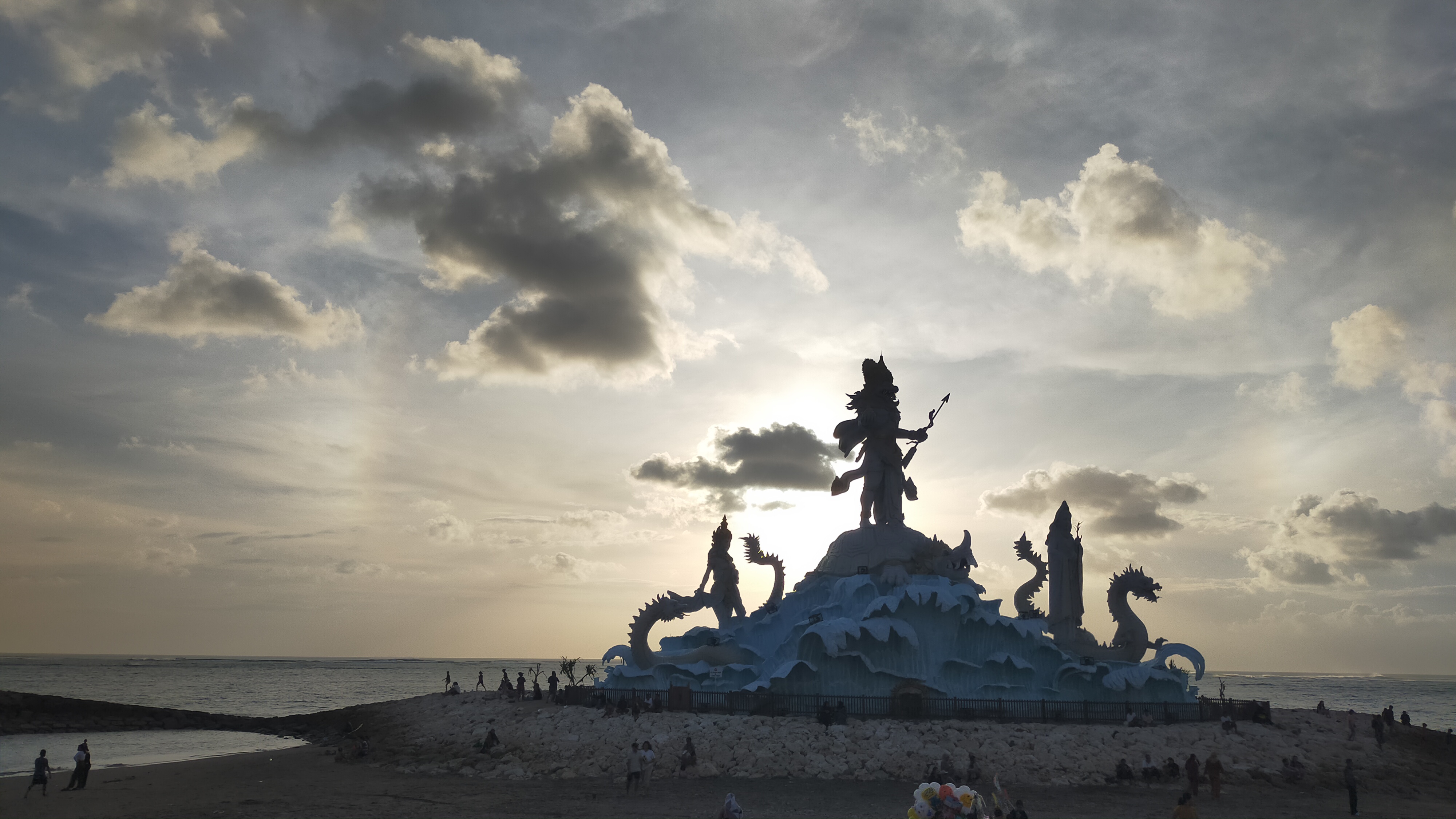 Breathtaking Hindu statue silhouette at sunset on Bali’s coast near Pantai Kuta during a UNIKAT E-Bike tour