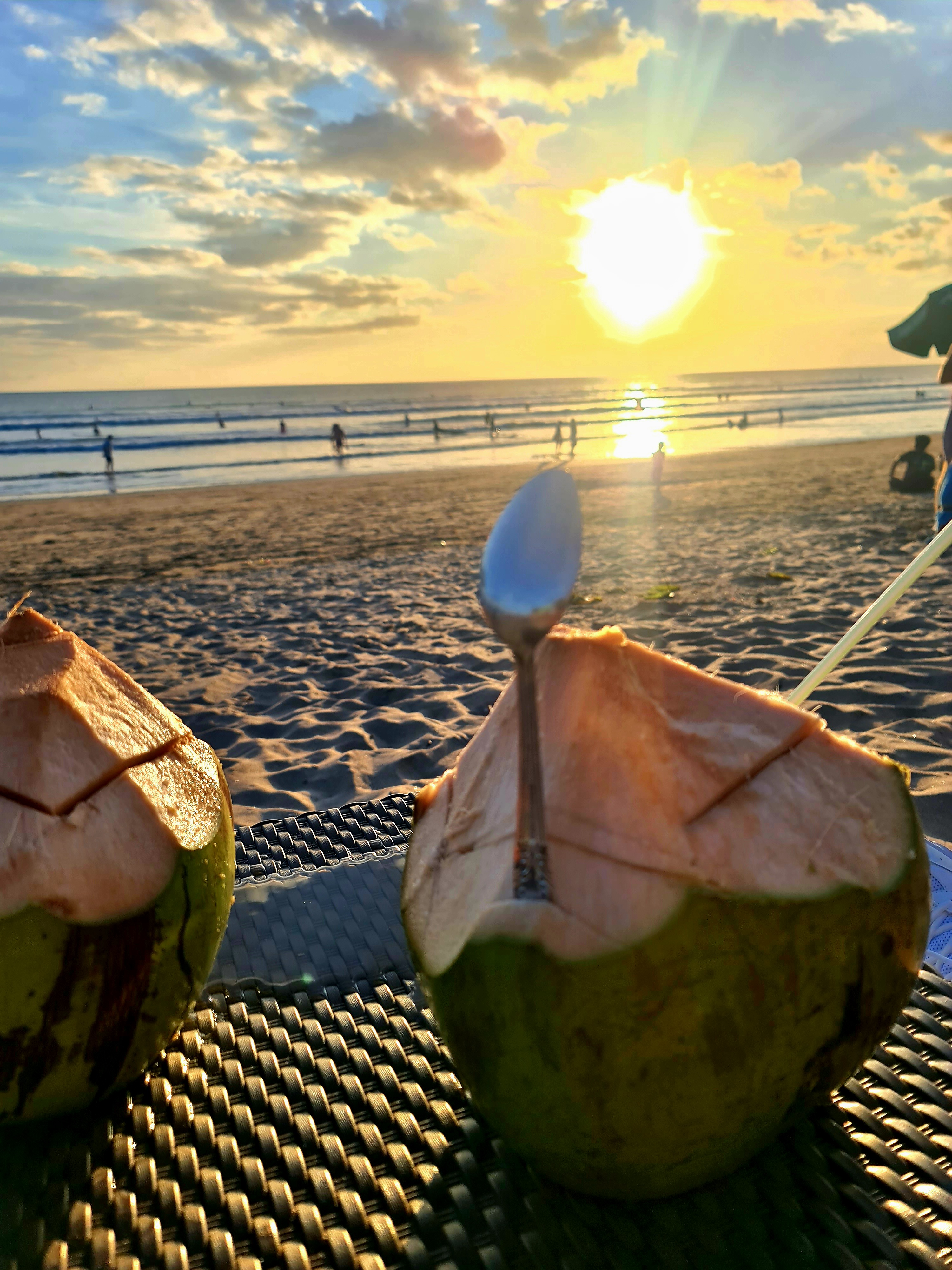 Fresh coconuts on Seminyak beach at golden sunset — the famous coconut stop on UNIKAT Ride with Style tour